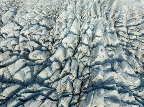 Aerial view of the glacial ice field etched with deep crevasses and shadowed patterns creates a stark textured landscape Fjallsarlon Sveitarfélagið Hornafjörður Iceland. Aerial view of the glacial ice field etched with deep crevasses and shadowed patterns creates a stark textured landscape Fjallsarlon Sveitarfélagið Hornafjörður Iceland.