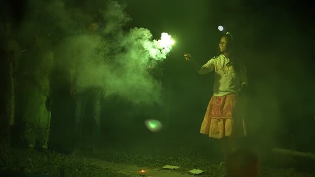 View of a girl playing with green sparklers at night Bangladesh. View of a girl playing with green sparklers at night Bangladesh.