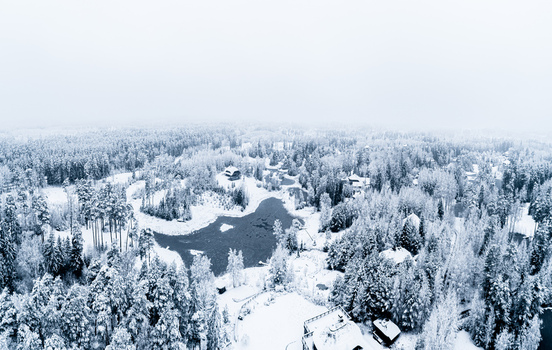Aerial view of a snow covered forest landscape surrounding a frozen lake in Latvia. Aerial view of a snow covered forest landscape surrounding a frozen lake in Latvia.