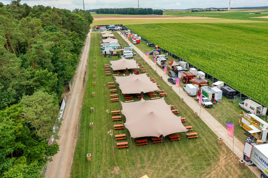 Herzogenaurach Germany 25 July 2025 Aerial view of Open Beatz Festival with large tents food stalls and green fields under a cloudy sky. Herzogenaurach Germany 25 July 2025 Aerial view of Open Beatz Festival with large tents food stalls and green fields under a cloudy sky.