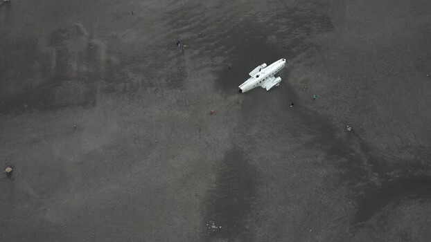 Aerial view of Solheimasandur Plane Wreck on dark sand Iceland.