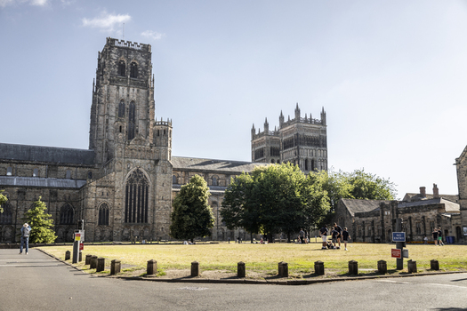 Durham England United Kingdom 13 July 2026 View of Durham Cathedral with its historic stone towers green trees and people relaxing on the lawn under a clear blue sky. Durham England United Kingdom 13 July 2026 View of Durham Cathedral with its historic stone towers green trees and people relaxing on the lawn under a clear blue sky.