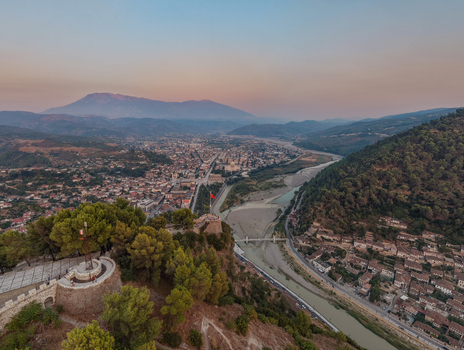 Aerial view of the historic Berat Castle overlooking the city of Berat the winding Osum River and the surrounding mountains in Berat Berat County Albania. Aerial view of the historic Berat Castle overlooking the city of Berat the winding Osum River and the surrounding mountains in Berat Berat County Albania.