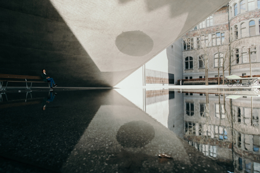Zurich Switzerland 02 April 2023 View of the National Museum s architecture reflected in a still puddle where light and shadow dance on the concrete creating a mesmerizing contrast. Zurich Switzerland 02 April 2023 View of the National Museum s architecture reflected in a still puddle where light and shadow dance on the concrete creating a mesmerizing contrast.