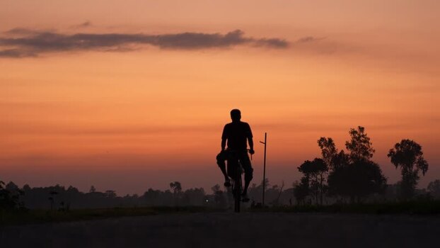 View of a man riding a bicycle at sunset in Bogura Bangladesh. View of a man riding a bicycle at sunset in Bogura Bangladesh.