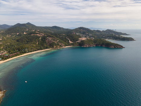 Aerial view of the coastline of Ko Pha Ngan with turquoise waters sandy beaches and lush green hills in Ko Pha ngan District Surat Thani Thailand.