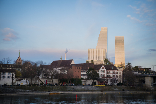 Basel Switzerland 10 March 2025 View of the towering Messe Basel skyscrapers juxtaposed against the quaint old town architecture reflecting in the tranquil waters. Basel Switzerland 10 March 2025 View of the towering Messe Basel skyscrapers juxtaposed against the quaint old town architecture reflecting in the tranquil waters.