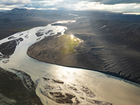 Aerial view of Landmannalaugar with a braided river winding through a dramatic volcanic landscape dark mountains and green moss in Rangarthing ytra Iceland. Aerial view of Landmannalaugar with a braided river winding through a dramatic volcanic landscape dark mountains and green moss in Rangarthing ytra Iceland.