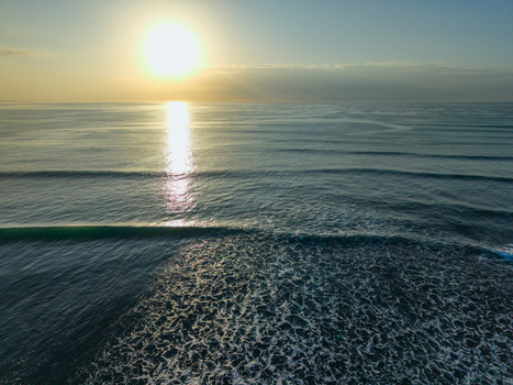 Aerial view of the sun kissing the rippled surface of the ocean with its light reflecting off the water like diamonds Kadrihnitin Socotra Yemen. Aerial view of the sun kissing the rippled surface of the ocean with its light reflecting off the water like diamonds Kadrihnitin Socotra Yemen.
