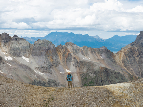 Aerial view of a hiker standing on a rocky ridge in Yankee Boy Basin with Mount Sneffels in the background within the San Juan Mountain Range Ouray Colorado United States. Aerial view of a hiker standing on a rocky ridge in Yankee Boy Basin with Mount Sneffels in the background within the San Juan Mountain Range Ouray Colorado United States.