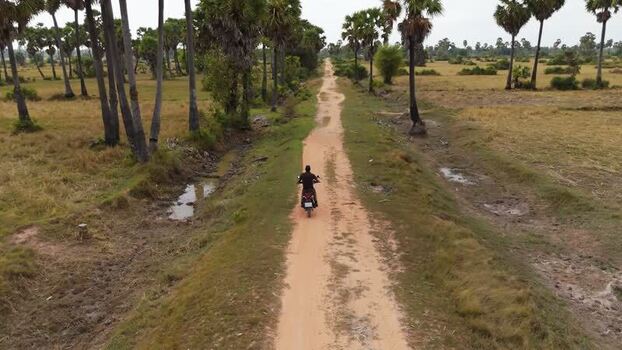 Aerial view of motorcycle on dirt road in Cambodia. Aerial view of motorcycle on dirt road in Cambodia.