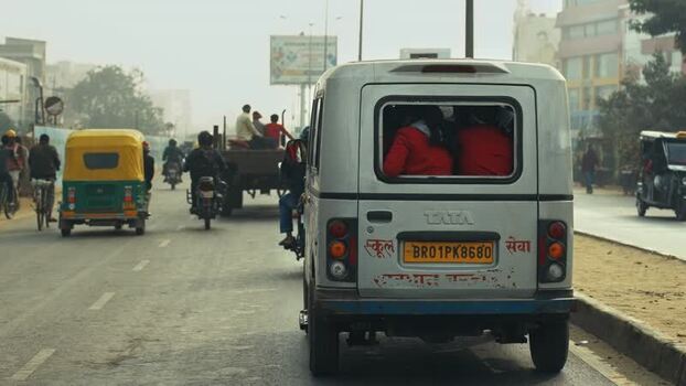 View of busy street traffic with a white van and rickshaws India.