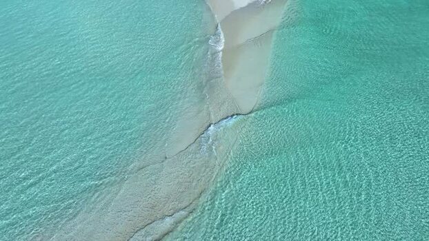 Aerial view of a white sandbar in turquoise waters Maldives.
