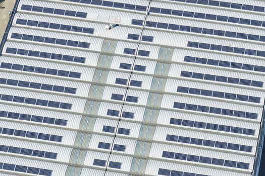 Aerial view of a large industrial building roof covered with rows of solar panels in Arezzo Tuscany Italy. Aerial view of a large industrial building roof covered with rows of solar panels in Arezzo Tuscany Italy.