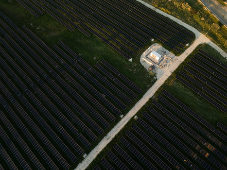 Aerial view of a solar panel farm with rows of photovoltaic modules and a small utility building under warm sunset light Augusta Sicily Italy. Aerial view of a solar panel farm with rows of photovoltaic modules and a small utility building under warm sunset light Augusta Sicily Italy.