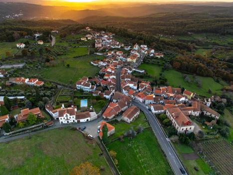 Aerial view of the historic village of Vila Pouca da Beira with red tiled houses nestled among green hills and forests at sunset Vila Pouca da Beira Coimbra Portugal.