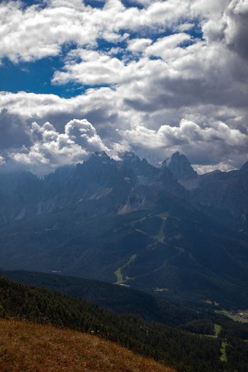 View of the jagged peaks of the Dolomites under a dramatic cloudy sky with forested slopes in the foreground Rocca Pietore Veneto Italy. View of the jagged peaks of the Dolomites under a dramatic cloudy sky with forested slopes in the foreground Rocca Pietore Veneto Italy.