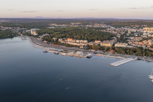 Aerial view of the coastal city with its harbor boats and urban architecture along the Adriatic Sea in Pula Istarska zupanija Croatia. Aerial view of the coastal city with its harbor boats and urban architecture along the Adriatic Sea in Pula Istarska zupanija Croatia.