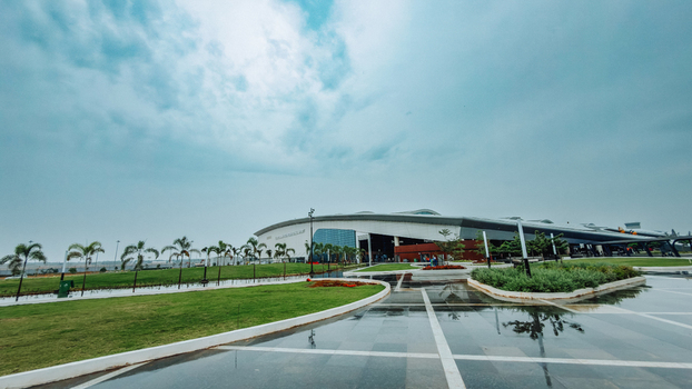 Bhogapuram Andhra Pradesh India 22 August 2026 View of the modern terminal building at Alluri Sitarama Raju International Airport with landscaped lawns and wet paved walkways under a cloudy sky. Bhogapuram Andhra Pradesh India 22 August 2026 View of the modern terminal building at Alluri Sitarama Raju International Airport with landscaped lawns and wet paved walkways under a cloudy sky.