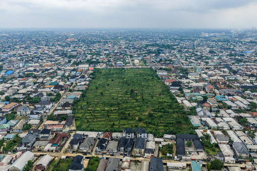 Port Harcourt Rivers Nigeria 03 July 2026 Aerial view of a large green agricultural plot surrounded by dense urban residential housing and rooftops under a cloudy sky. Port Harcourt Rivers Nigeria 03 July 2026 Aerial view of a large green agricultural plot surrounded by dense urban residential housing and rooftops under a cloudy sky.