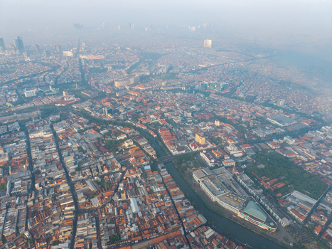 Genteng East Java Indonesia 13 August 2026 Aerial view of Surabaya Old Town featuring dense historic rooftops a central canal and urban infrastructure under a hazy sky. Genteng East Java Indonesia 13 August 2026 Aerial view of Surabaya Old Town featuring dense historic rooftops a central canal and urban infrastructure under a hazy sky.