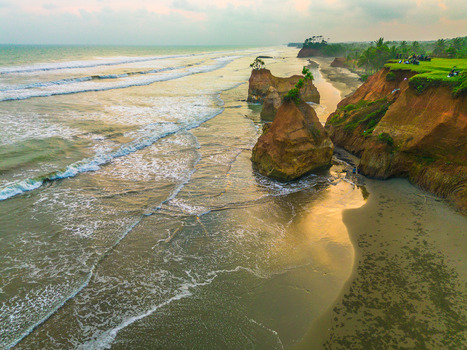 Aerial view of rock formations on the beach with cliffs and ocean waves in Bali Indonesia. Aerial view of rock formations on the beach with cliffs and ocean waves in Bali Indonesia.