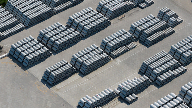 Aerial view of neatly stacked concrete pipes in an industrial storage yard with geometric patterns and grey textures Oosterhout North Brabant Netherlands. Aerial view of neatly stacked concrete pipes in an industrial storage yard with geometric patterns and grey textures Oosterhout North Brabant Netherlands.