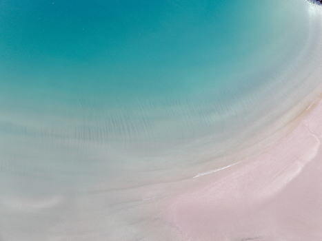 Aerial view of Gruinard Bay featuring turquoise water and pink sand ripples in Gruinard Scotland United Kingdom. Aerial view of Gruinard Bay featuring turquoise water and pink sand ripples in Gruinard Scotland United Kingdom.