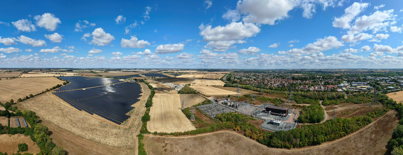 Aerial view of Eaton Socon Substation solar farm and battery energy storage systems surrounded by golden agricultural fields and the town of St. Neots England United Kingdom. Aerial view of Eaton Socon Substation solar farm and battery energy storage systems surrounded by golden agricultural fields and the town of St. Neots England United Kingdom.