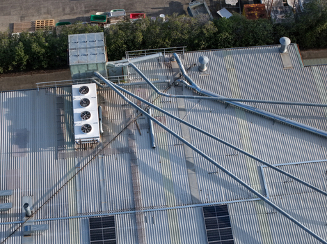 Aerial view of industrial factory rooftops in Kilsyth South featuring corrugated metal surfaces ventilation units and piping systems in Melbourne VIC Australia. Aerial view of industrial factory rooftops in Kilsyth South featuring corrugated metal surfaces ventilation units and piping systems in Melbourne VIC Australia.