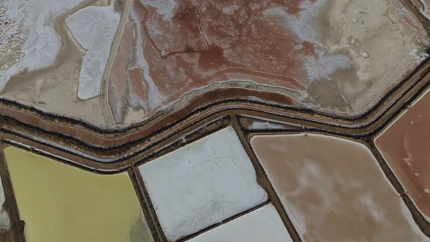 Aerial view of colorful salt evaporation ponds with geometric basins and narrow paths in Cagliari Sardinia Italy. Aerial view of colorful salt evaporation ponds with geometric basins and narrow paths in Cagliari Sardinia Italy.