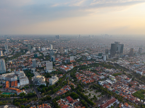 Surabaya Indonesia 28 August 2026 Aerial view of the sprawling cityscape of Surabaya featuring dense residential areas modern high rise buildings and lush green spaces.
