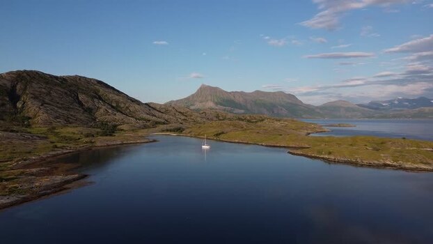 Aerial view of a sailboat in a calm bay in Senja Norway.