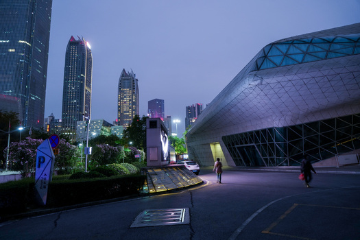 Guangzhou China 24 February 2024 View of the modern Guangzhou Opera House with its geometric glass facade at twilight featuring pedestrians walking on the plaza. Guangzhou China 24 February 2024 View of the modern Guangzhou Opera House with its geometric glass facade at twilight featuring pedestrians walking on the plaza.