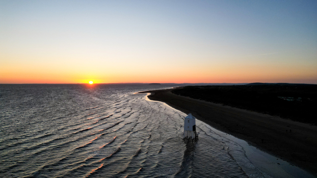 Aerial view of Sunset at Burnham on Sea Low Lighthouse with the tide coming in along the sandy beach and calm sea waves in Burnham on Sea England United Kingdom. Aerial view of Sunset at Burnham on Sea Low Lighthouse with the tide coming in along the sandy beach and calm sea waves in Burnham on Sea England United Kingdom.