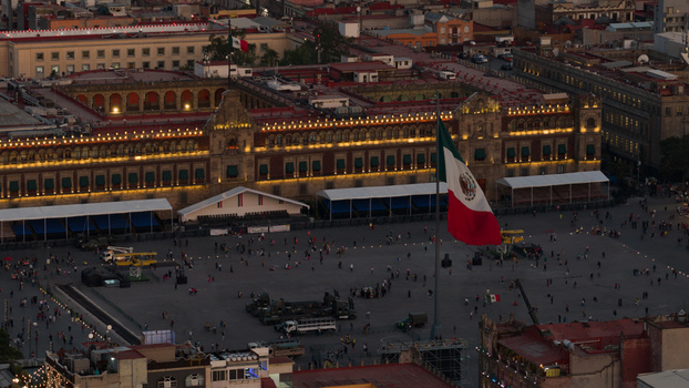 Mexico City Mexico 15 July 2026 Aerial view of the Zocalo square featuring the National Palace illuminated at dusk with a large Mexican flag flying and people gathered in the plaza. Mexico City Mexico 15 July 2026 Aerial view of the Zocalo square featuring the National Palace illuminated at dusk with a large Mexican flag flying and people gathered in the plaza.