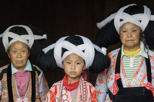 Gaoxing China 29 April 2026 View of three Long Horn Miao women wearing traditional large yarn headdresses and colorful embroidered ethnic clothing. Gaoxing China 29 April 2026 View of three Long Horn Miao women wearing traditional large yarn headdresses and colorful embroidered ethnic clothing.