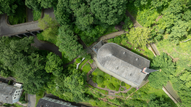 Aerial view of St. Menas church nestled among dense green trees and a winding road in Koblenz Rheinland Pfalz Germany. Aerial view of St. Menas church nestled among dense green trees and a winding road in Koblenz Rheinland Pfalz Germany.