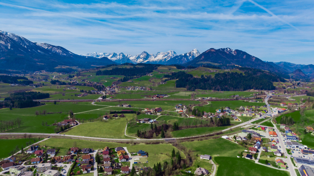 Aerial view of verdant fields meet quaint villages nestled against the majestic snow capped Alps in the Windischgarsten valley Windischgarsten Upper Austria Austria. Aerial view of verdant fields meet quaint villages nestled against the majestic snow capped Alps in the Windischgarsten valley Windischgarsten Upper Austria Austria.