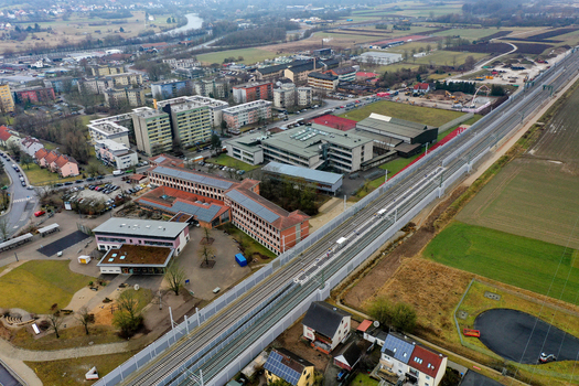 Aerial view of Forchheim featuring railway tracks residential buildings and industrial zones under a soft daylight Forchheim Bavaria Germany.