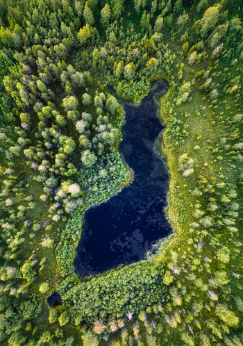 Aerial view of Neitokainen lake shaped like the map of Finland surrounded by dense coniferous forest in Kittila Lapland Finland. Aerial view of Neitokainen lake shaped like the map of Finland surrounded by dense coniferous forest in Kittila Lapland Finland.