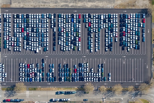 Aerial view of a vast parking lot brimming with neatly arranged rows of cars a sea of metallic hues reflecting the sunlight Sausheim Grand Est France.