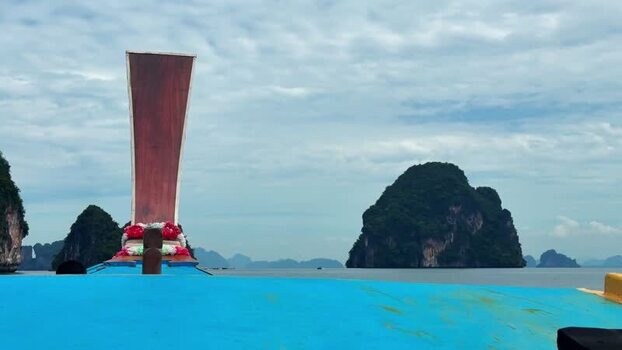 View of a longtail boat and limestone karsts Thailand.