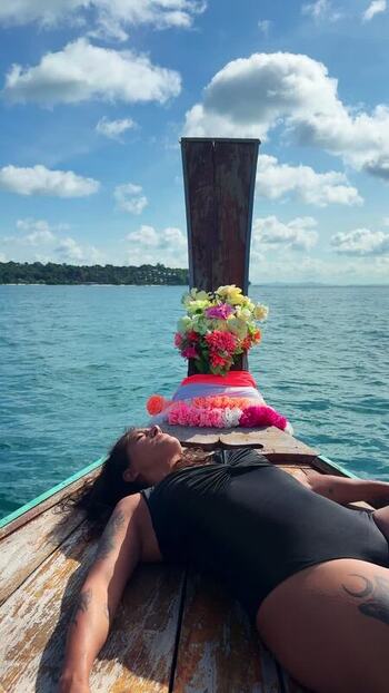 View of a person relaxing on a longtail boat Thailand.