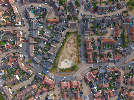 Aerial view of a modern residential housing estate featuring rows of houses winding streets and a central park area in Bedford England United Kingdom. Aerial view of a modern residential housing estate featuring rows of houses winding streets and a central park area in Bedford England United Kingdom.