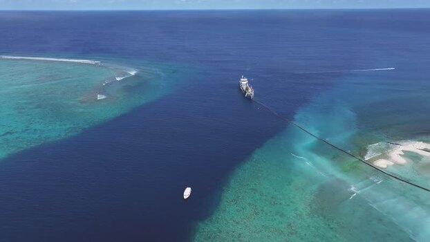 Aerial view of a large ship in a deep blue channel Maldives.