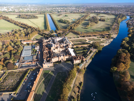 Aerial view of Hampton Court Palace surrounded by historic gardens and the River Thames in Molesey England United Kingdom. Aerial view of Hampton Court Palace surrounded by historic gardens and the River Thames in Molesey England United Kingdom.
