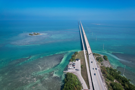 Aerial view of The Overseas Highway stretching across turquoise waters and small islands under a clear blue sky Key Largo Florida United States. Aerial view of The Overseas Highway stretching across turquoise waters and small islands under a clear blue sky Key Largo Florida United States.