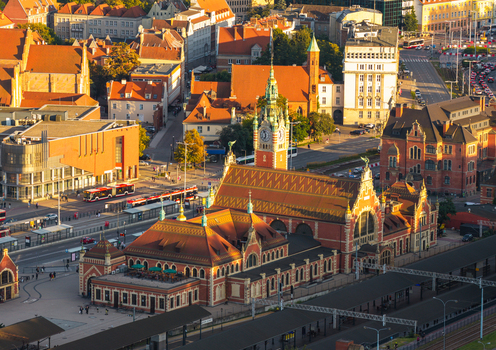 Aerial view of the historic Gdansk Main Railway Station with its clock tower surrounded by urban architecture and red tiled roofs in Gdansk Pomeranian Voivodeship Poland. Aerial view of the historic Gdansk Main Railway Station with its clock tower surrounded by urban architecture and red tiled roofs in Gdansk Pomeranian Voivodeship Poland.