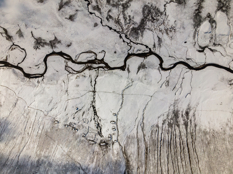 Aerial view of the snow covered terrain of Babusar Pass with a winding dark river and small remote settlements Babusar KPK Pakistan. Aerial view of the snow covered terrain of Babusar Pass with a winding dark river and small remote settlements Babusar KPK Pakistan.